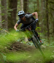 Female mountain biker riding her SHIMANO DOERE XT equipped bike riding down a hill